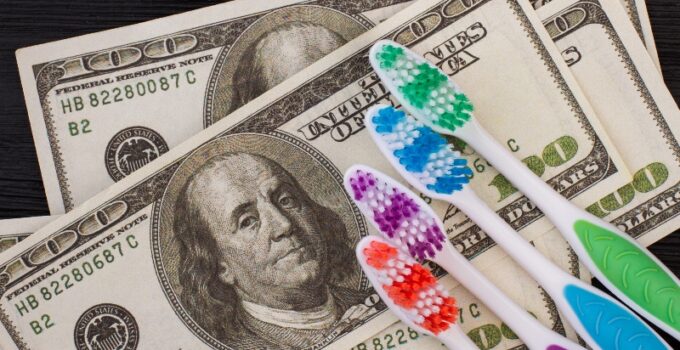 Close up of money and toothbrush. American dollars and colorful toothbrush.
